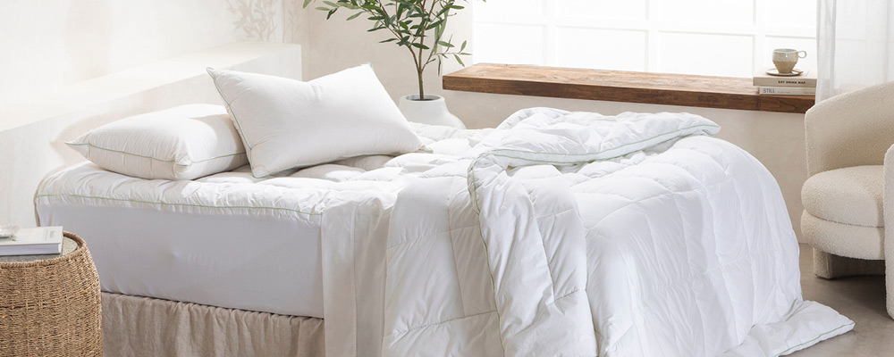 Picture features a bed with Greenfirst Hypoallergenic mattress topper, quilt and two pillows.