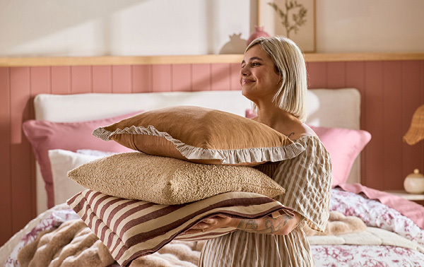Pillow Talk Stylist Roxy Foster carrying a stack of cushions