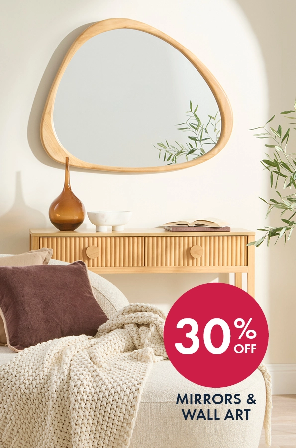 White couch with a cream throw, chocolate cushions and a light wood console with wood framed mirror.