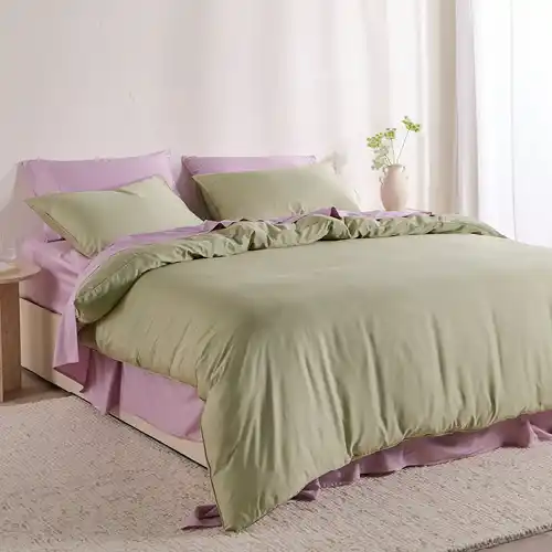A bed styled with lilac bamboo cotton sheet set and a soft fern green bamboo cotton quilt cover set