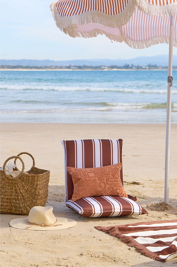Chocolate and white striped brach lounger with matching towel and umbrella