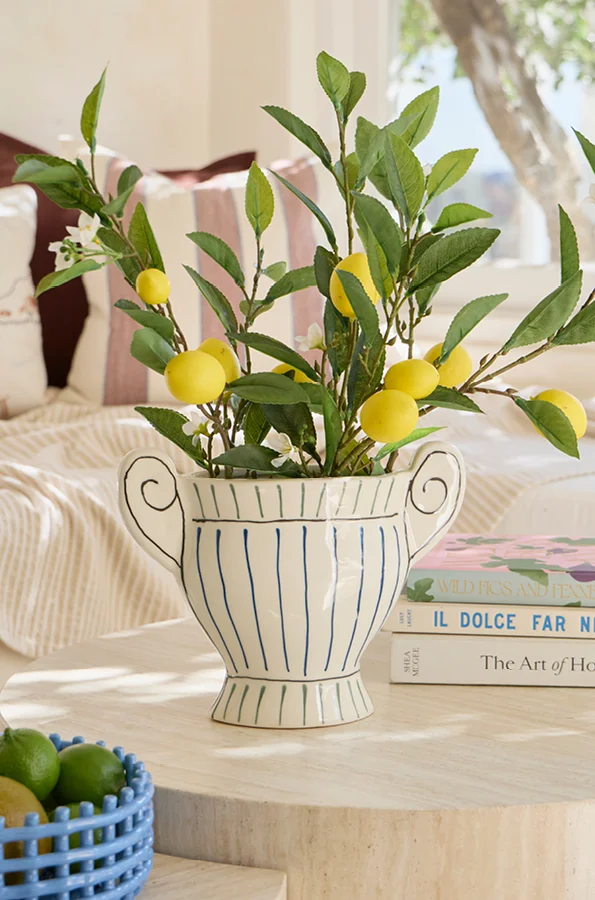 White and blue striped vase with lemon branches inside